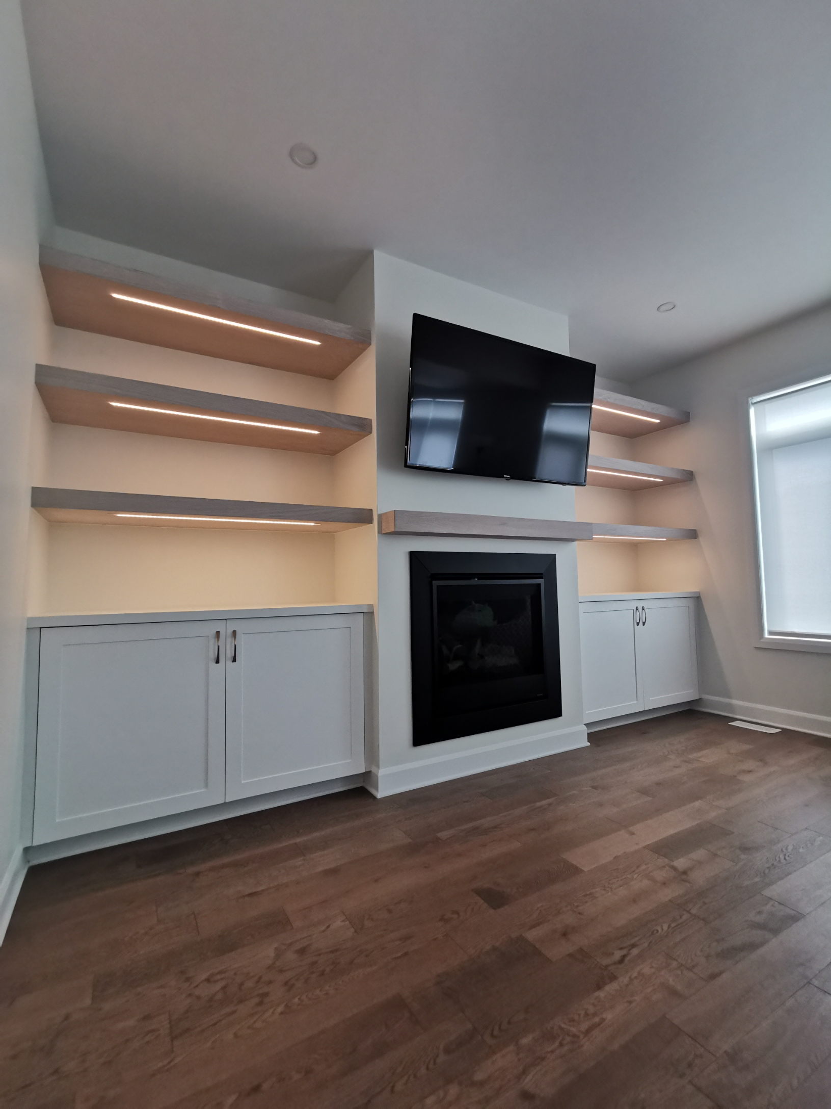Living room built ins with white oak floating shelves